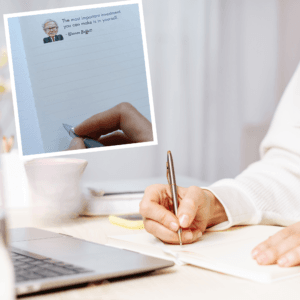 Person writing in the investing notebook at a desk