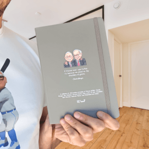 Hand holding the Notebook of Wisdom investing journal