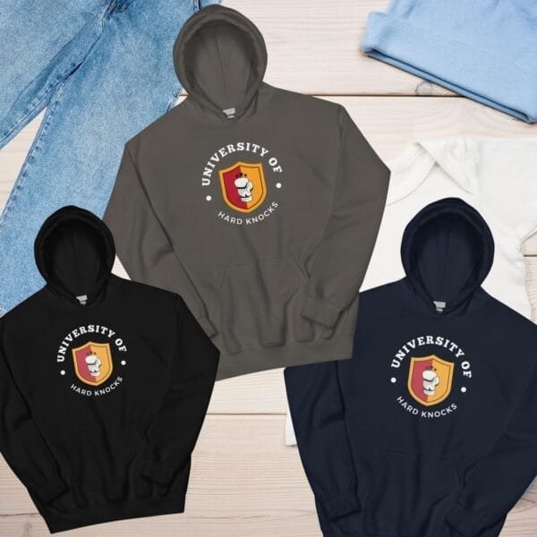 Detailed close-up of the University of Hard Knocks print on a hoodie, symbolizing real-world experience and resilience, Black "School of Hard Knocks" pullover hoodie, a motivational piece for investors and risk-takers.